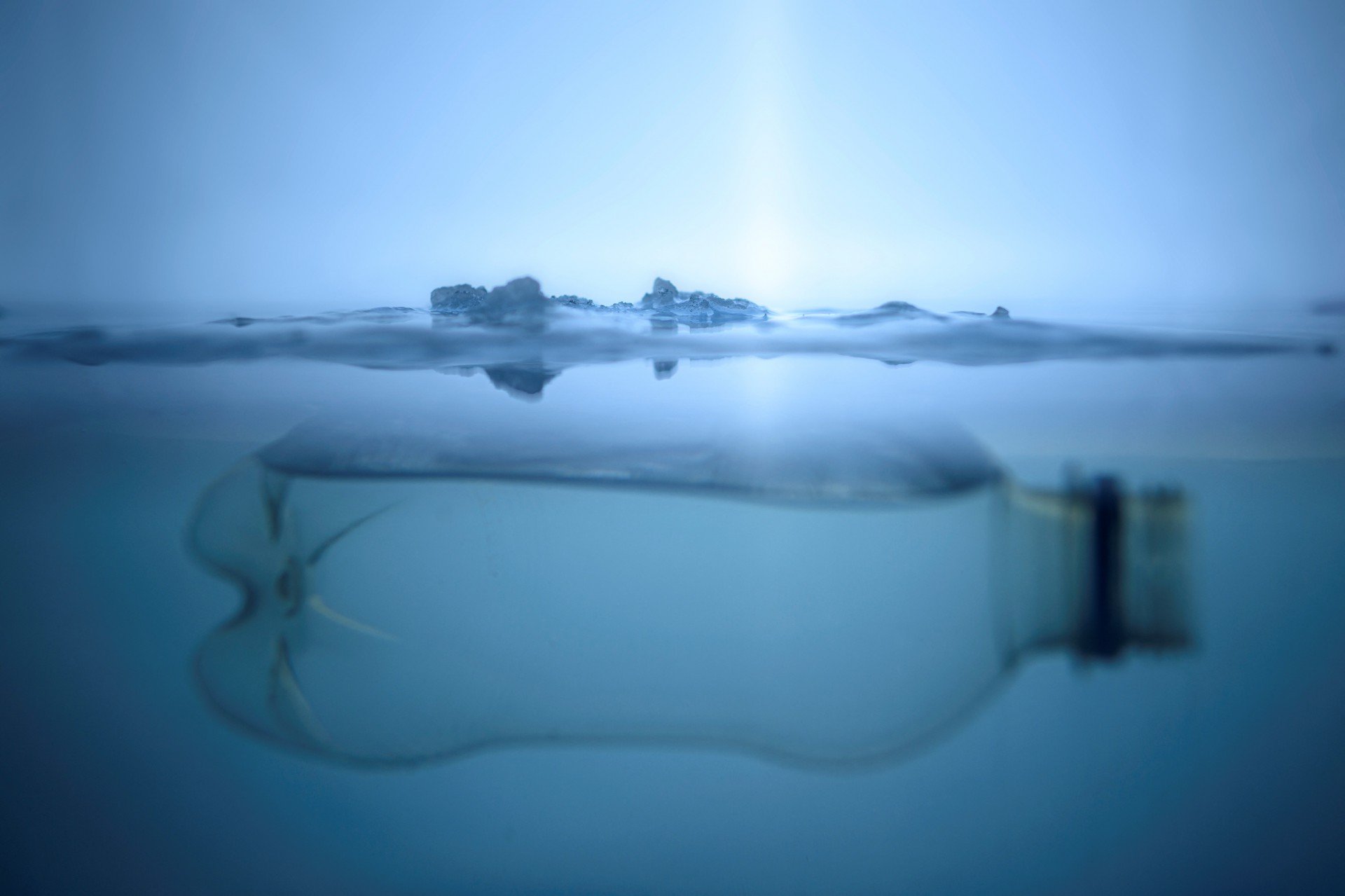 IMAGEM de 8/12/2022, em Vaasa, mostra garrafa de plástico flutua sob uma camada de gelo (Foto: OLIVIER MORIN / AFP)